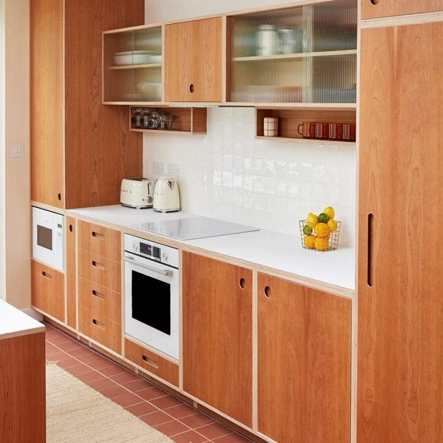 Cocina con muebles de madera, alacenas de vidrio y horno integrado
