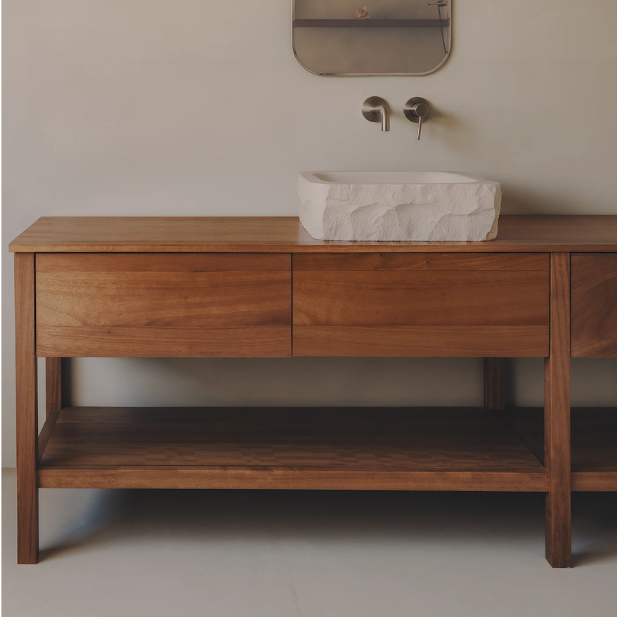 Mueble de baño en madera con cajones, repisa inferior y lavamanos de piedra