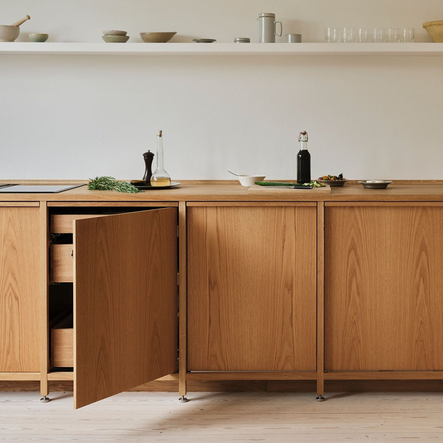 Muebles bajos de cocina en madera con puertas abiertas y repisa blanca